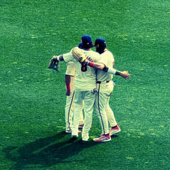 Baseball players hugging in the outfield